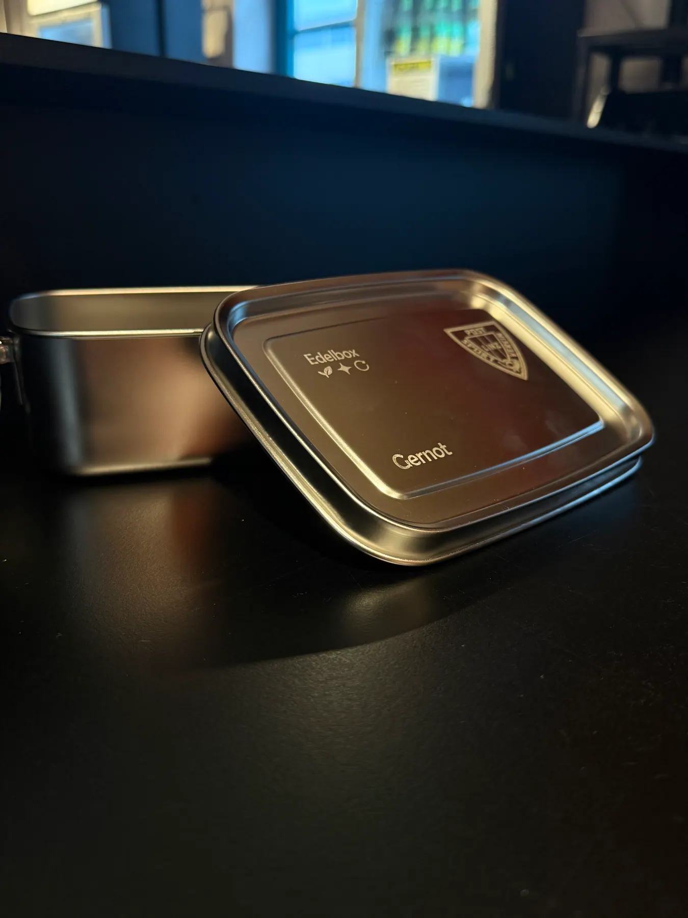 Offene Edelbox mit daneben liegendem Deckel auf dunklem Untergrund